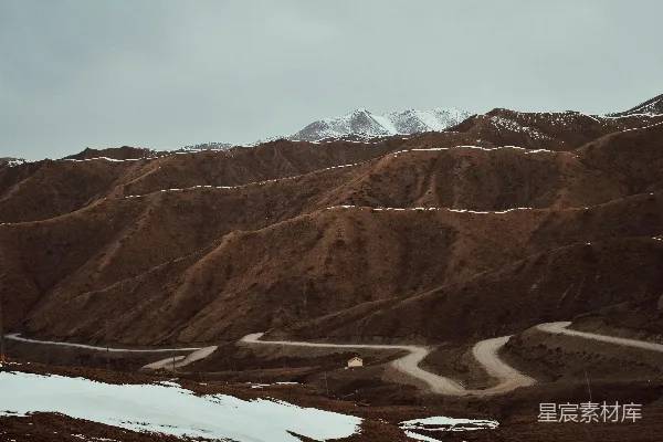 高清摄影 一条蜿蜒的山路，地上覆盖着积雪。