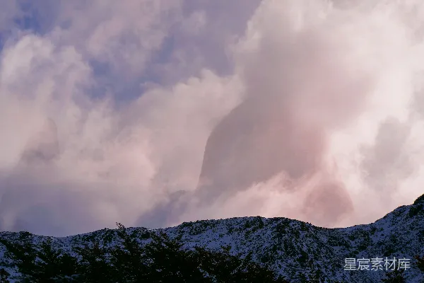 高清摄影 覆盖着积雪的山峰在阴云密布的天空下