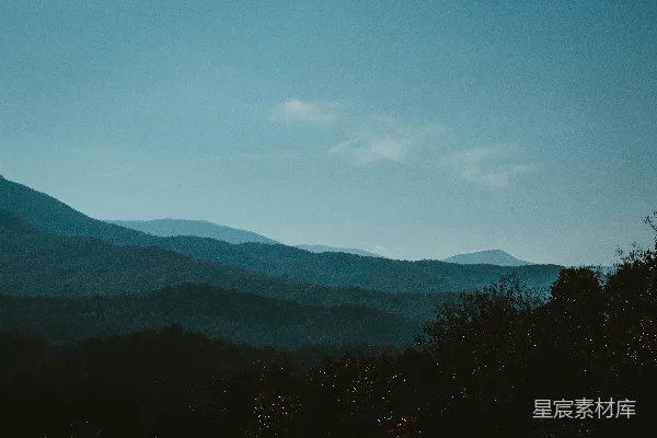 高清摄影 一座山脉的远景，前景中有树木。