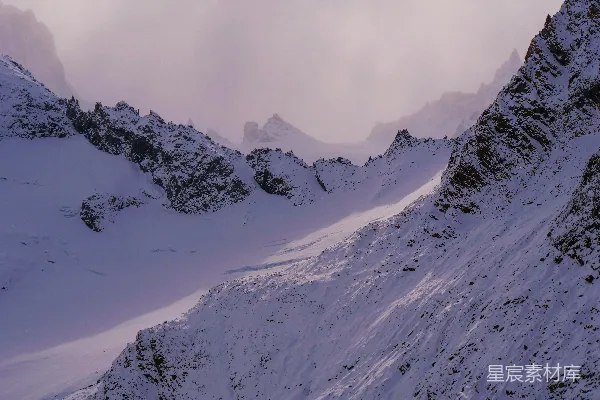 高清摄影 一座覆盖着积雪的山峰，背景是蓝天。