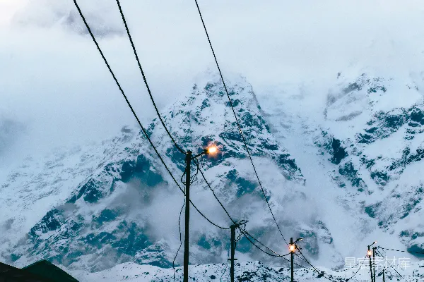 高清摄影 一座覆盖着积雪的山，街道上亮着路灯。