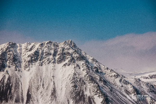 高清摄影 一座覆盖着白雪的山峰，在蓝天之下。
