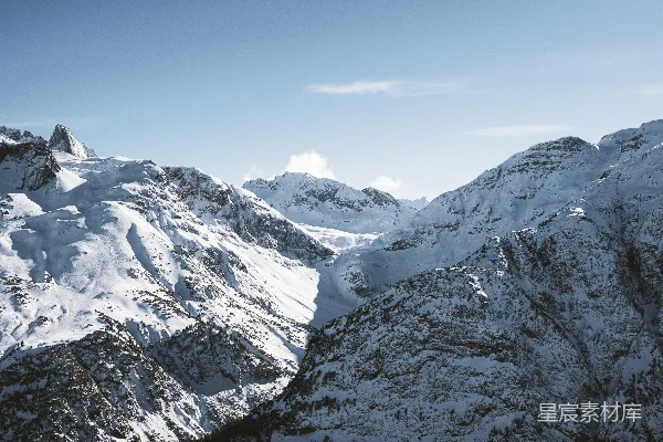 高清摄影 连绵的山峦覆盖着白雪，蓝天映衬之下。