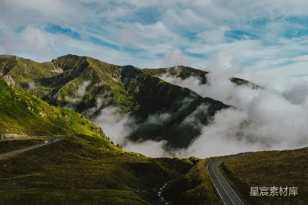高清摄影 一条穿过山谷的小路，背景中有山脉。