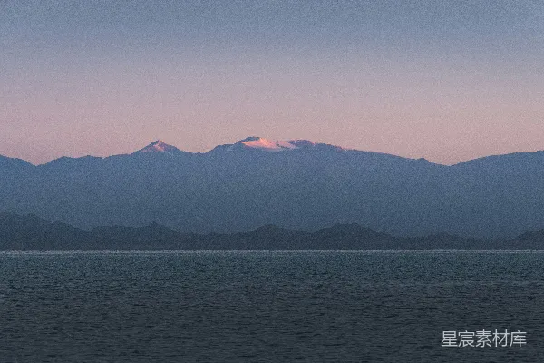 高清摄影 夕阳下，山峰凌驾于海面之上。