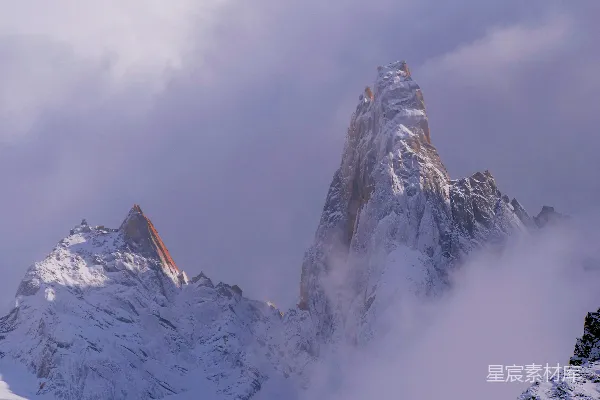 高清摄影 一座覆盖着积雪的山，背景中有云。