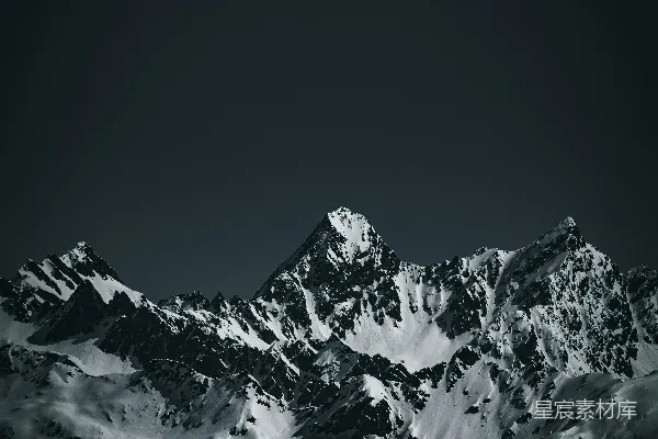 高清摄影 乌云密布的天空下，被积雪覆盖的山峰