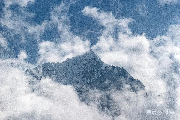 高清摄影 一座被云雾笼罩的高山，在蓝天之下。