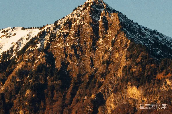 高清摄影 白雪覆盖的山峰沐浴在金色阳光之中