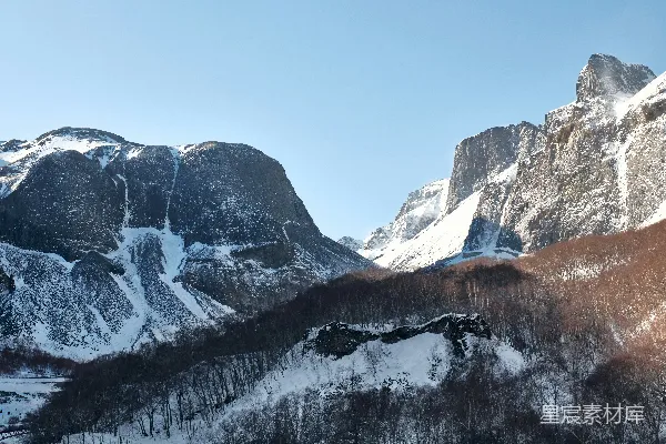 高清摄影 覆盖着积雪的山脉，背景中还有树木和更多的山脉。