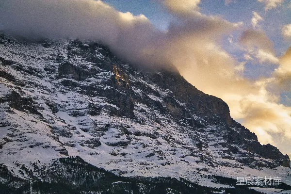 高清摄影 一座被雪覆盖的山峰，天空中有云。