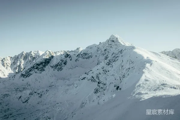 高清摄影 一座被雪覆盖的山，背景是蓝天。
