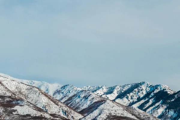高清摄影 白天的白色天空下覆盖着积雪的山峰