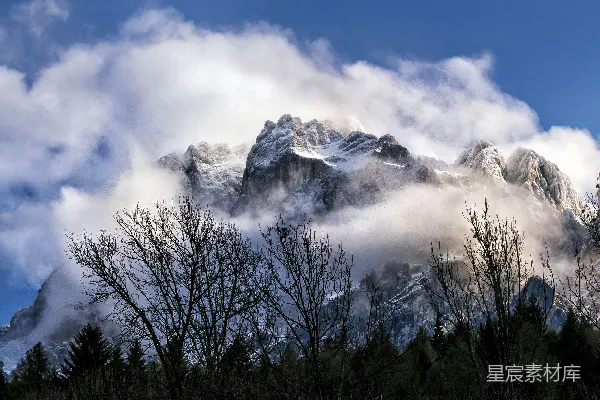高清摄影 被云雾缭绕的雪山和下面的森林。