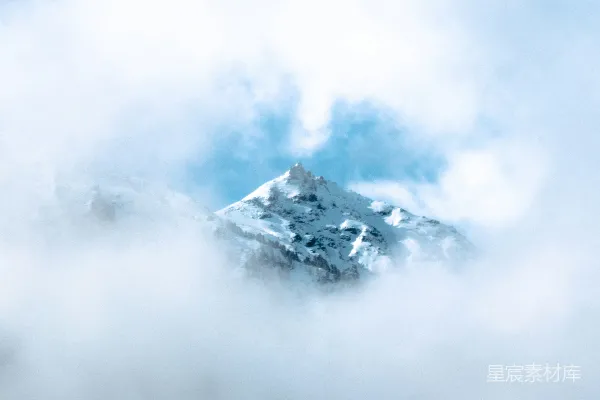 高清摄影 白天云层覆盖下的白雪皑皑的山峰