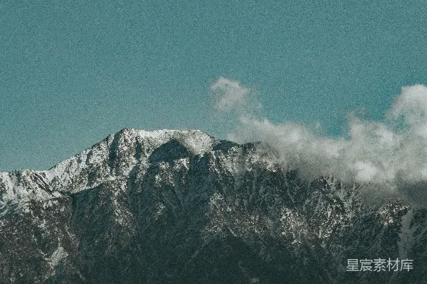 高清摄影 一座被雪覆盖的山脉，天空中有云。