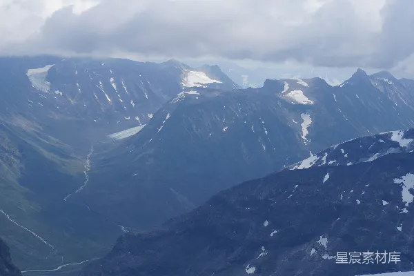 高清摄影 雪山峰峦与多云天下的山谷。