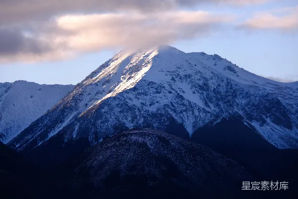 高清摄影 雪山峰顶部分被云层和阳光覆盖。
