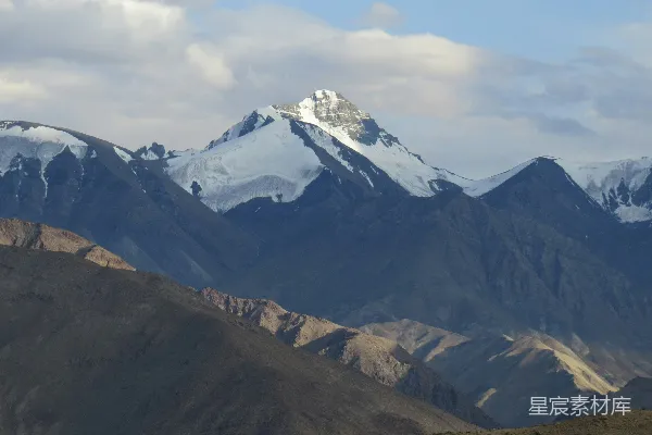 高清摄影 一座山脉，背景中有被白雪覆盖的山峰。
