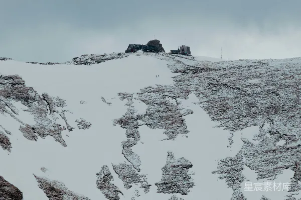 高清摄影 云层密布的天空下，覆盖着白雪的山峰。