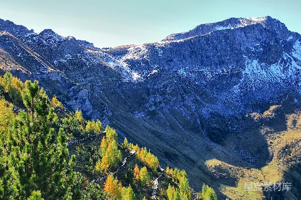 高清摄影 山路上的秋树和白雪覆盖的山峰