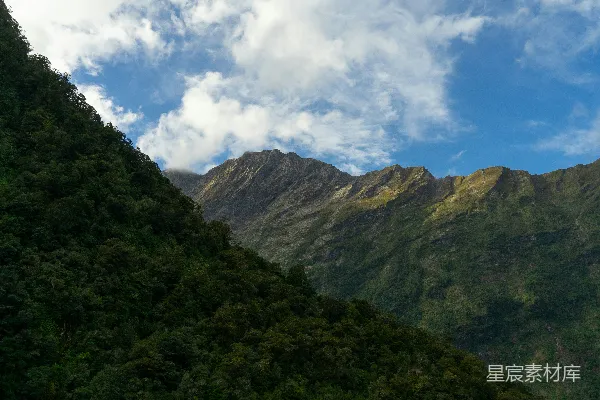 高清摄影 山峰在云层和蓝色的天空下耸立。