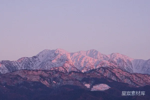 高清摄影 被柔和粉红色光线笼罩的雪山。