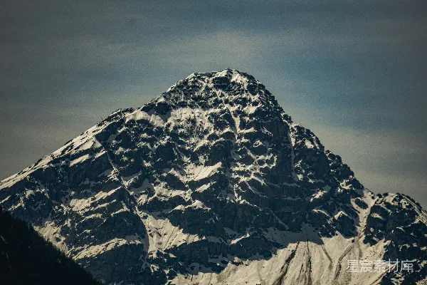 高清摄影 一座被大雪覆盖的山峰，背景是天空。