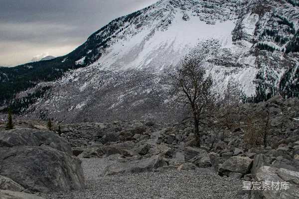 高清摄影 一座被雪和岩石覆盖的山在阴云密布的天空下