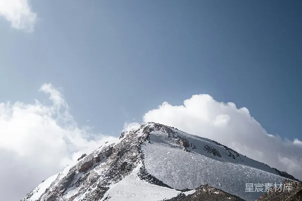 高清摄影 覆盖着积雪的山峰在部分多云的天空下
