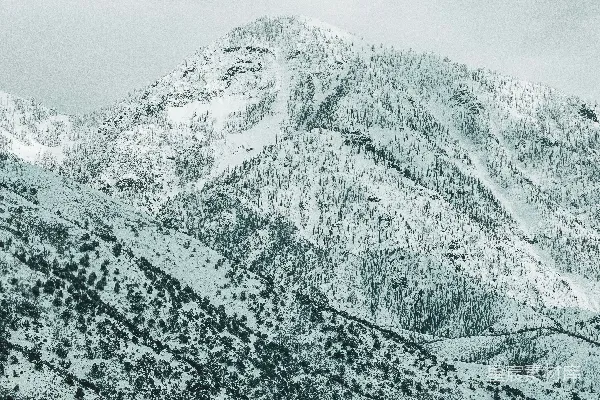 高清摄影 一座覆盖着积雪的山在阴云密布的天空下