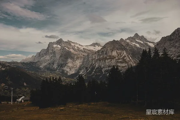 高清摄影 一座山峦的景色，前景是树木。