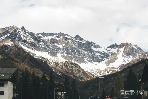 高清摄影 白雪覆盖的山脉耸立在村舍之上。