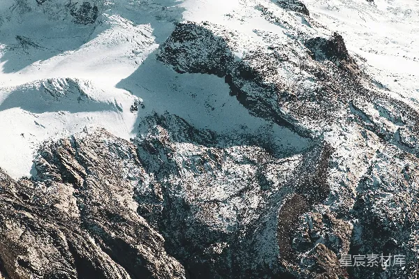 高清摄影 一座被雪覆盖的山，中间有一片湖泊。