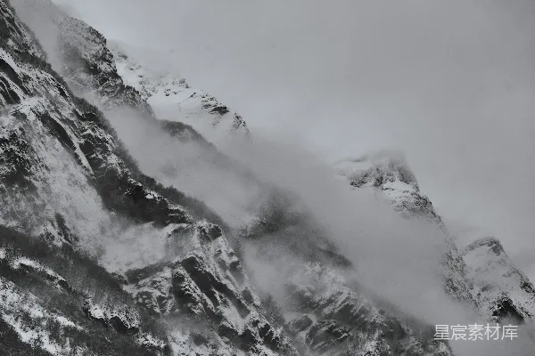 高清摄影 一座被积雪和云雾笼罩的高耸山峰