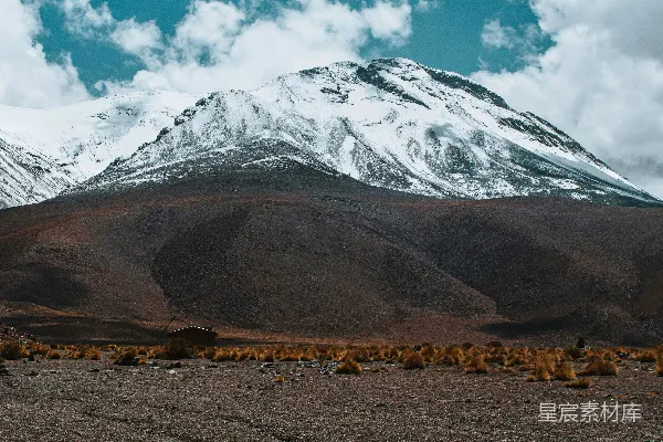 高清摄影 远处覆盖着积雪的山脉，天空中有几朵云。