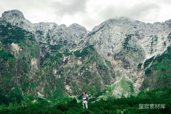 高清摄影 站在群山环绕的树木之间的一位男士
