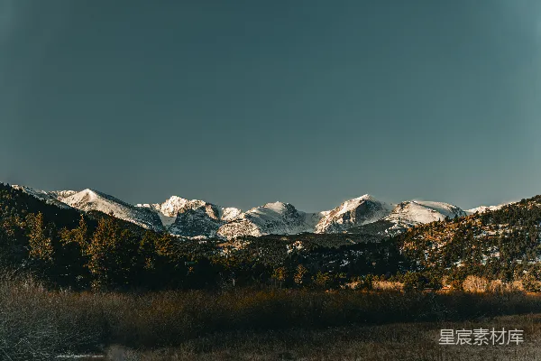 高清摄影 山峦被雪覆盖，草地呈现棕色。