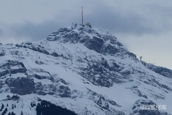高清摄影 一座覆盖着积雪的山峰，山顶上有一座广播塔。