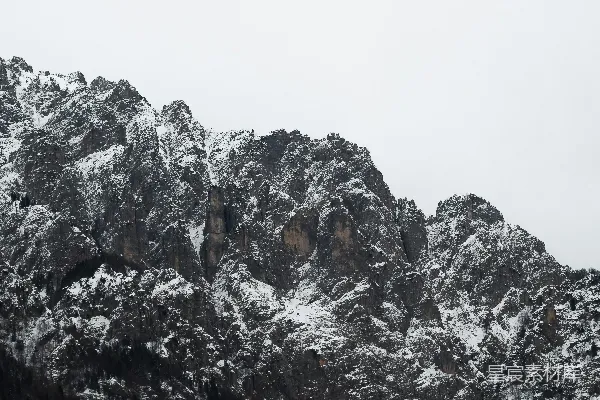高清摄影 一座覆盖着积雪的山峰，背景是蓝天。