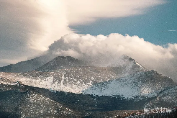 高清摄影 一座被雪覆盖的山峰，天空中有云。