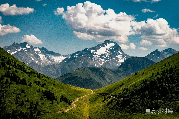 高清摄影 一条蜿蜒的山路穿过绿谷，通向雪山。