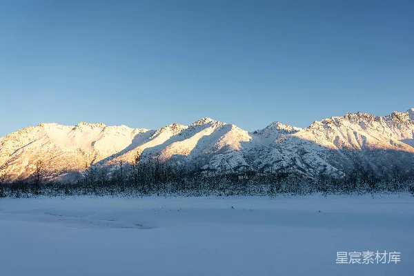 高清摄影 一片覆盖着积雪的田野，背景中有山脉。