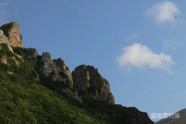 高清摄影 陡峭的岩石悬崖，下面是绿色植被。