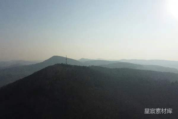 高清摄影 一幅风景画，有山丘和一座塔楼。