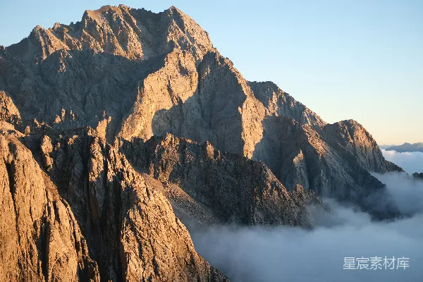 高清摄影 陡峭的山峰在云层之上沐浴在温暖的阳光之中