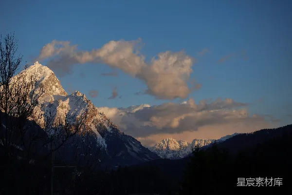 高清摄影 雪山峰顶被金色夕阳照亮。