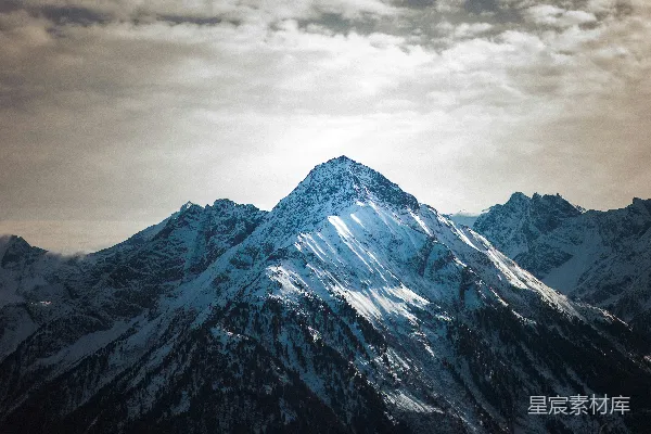 高清摄影 被白雪覆盖的山峰在变幻莫测的天空下