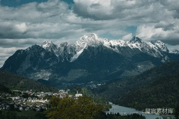 高清摄影 山谷小镇和河流上方雄伟的雪山。
