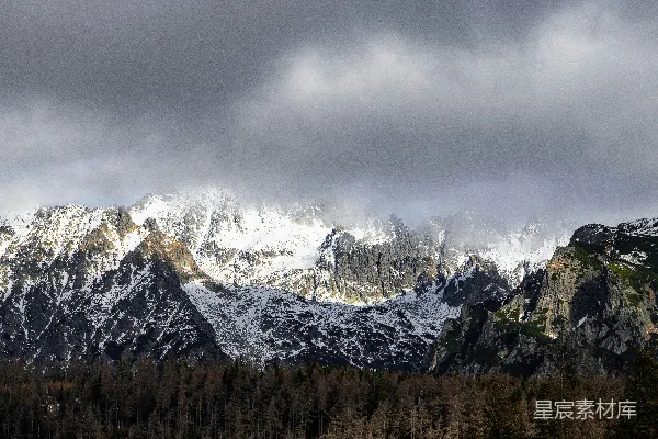 高清摄影 雪覆盖的群山在戏剧性的云层下